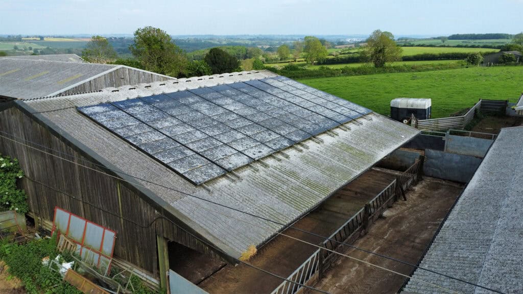 A 'before' photo of the same barn before it was cleaned. The solar panels are covered in dirt, grime, and mould.